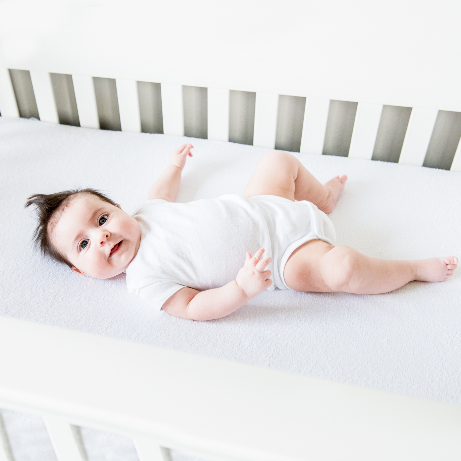 Pr1me Terry Mattress Protector in Twin Shown in Crib with Baby